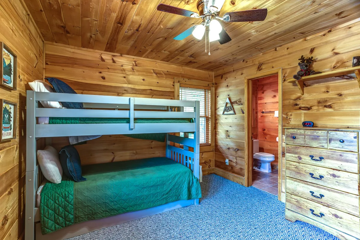 A bright, family-friendly bedroom with a sturdy bunk bed, cheerful wall art, and a dresser. The room feels playful yet restful—perfect for siblings, cousins, or friends to share bedtime stories or play games together.